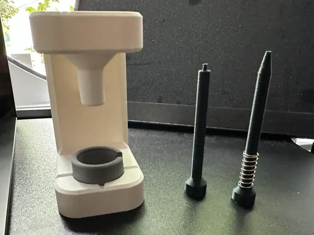 A printed white press stand with two black pushers for fitting watch hands